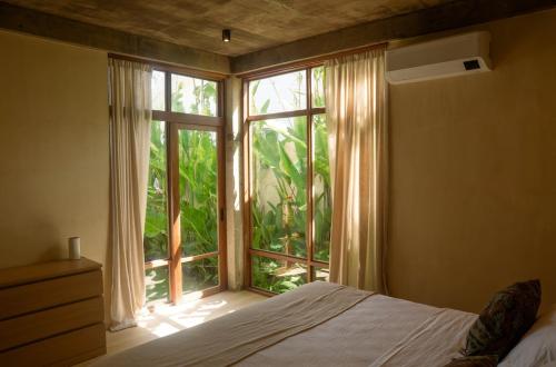 a bedroom with a bed and a large window at Casa Kalma in General Luna