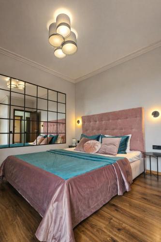 a bedroom with a large bed and a large mirror at Blue Apartment in Mukacheve
