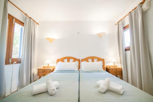 a bedroom with two beds with white pillows at Morans-C in Es Pujols