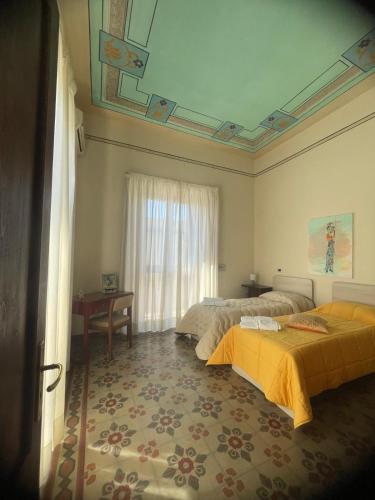a hotel room with two beds and a window at Mappet B&B in Melito di Porto Salvo