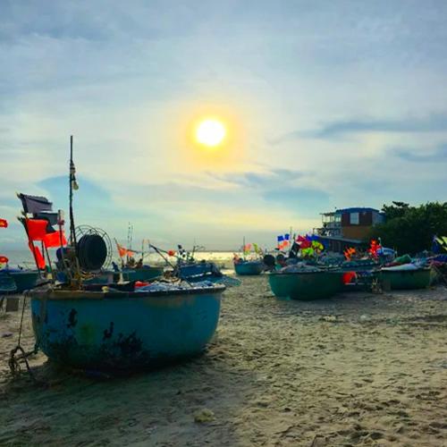 a group of boats sitting on a sandy beach at Bason Hotel Long Hải in Long Hai