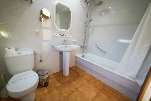 a bathroom with a toilet and a sink and a shower at Hotel Atlántico Sanxenxo in Montalvo