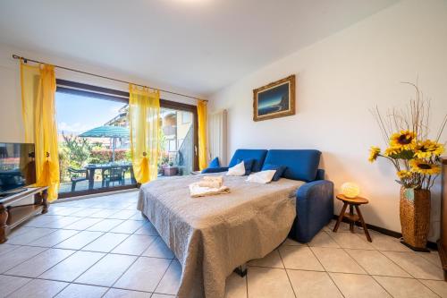 a bedroom with a blue bed and a large window at Casa Ester a due passi dal lago in Germignaga
