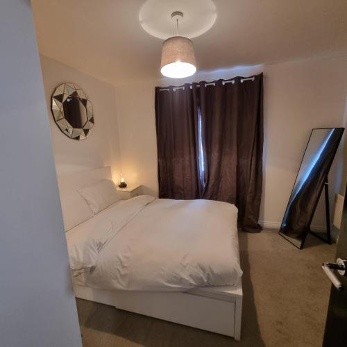 a bedroom with a white bed and a window at Cozy Flat with Parking in Goodmayes