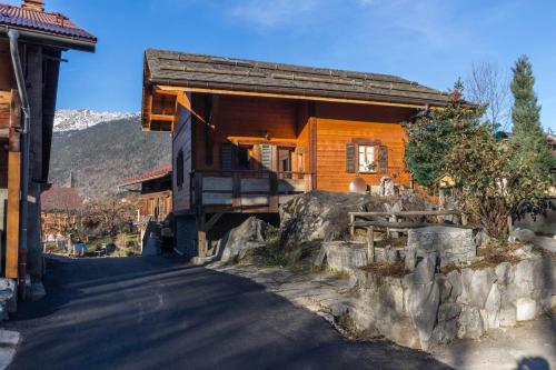 a wooden house with a porch on a street at Le Grenier 1821 - Mini chalet - Centre village - AravisTour in Saint-Jean-de-Sixt