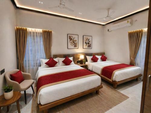 a hotel room with two beds and a chair at Shri Valli Residency in Palni