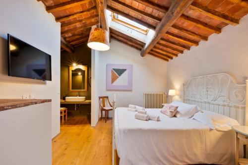 a bedroom with a white bed in a room at Tenuta La Fratta in Sinalunga