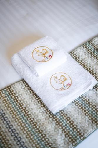 two towels sitting on top of a bed at Le Coq Elysium - Exceptional 220 sqm Penthouse - Private Terrace & Jacuzzi - AC - 3 Parking Spaces in Menton