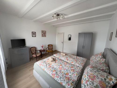 a bedroom with a bed and a couch and a tv at Ferienwohnung Kirschtraum in Mülheim-Kärlich