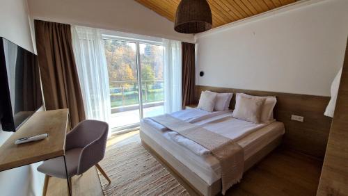 ein Schlafzimmer mit einem Bett und einem großen Fenster in der Unterkunft Waterside SPA Hotel in Ognyanovo