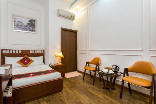 a bedroom with a bed and a table and chairs at Indochine Apartments in Ho Chi Minh City