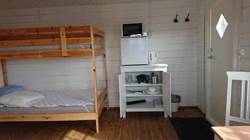 a bedroom with a bunk bed with a microwave at Möllergårdens Stugor in Ängelholm