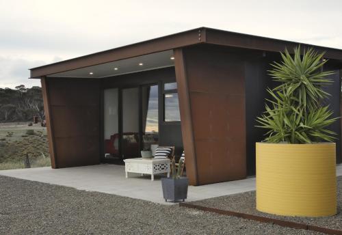 a building with a couch and two potted plants at The Rusty Kangaroo Hideaway - Ocean-View - Full Booking Service, Ferry, Experiences, Tour Option in Penneshaw