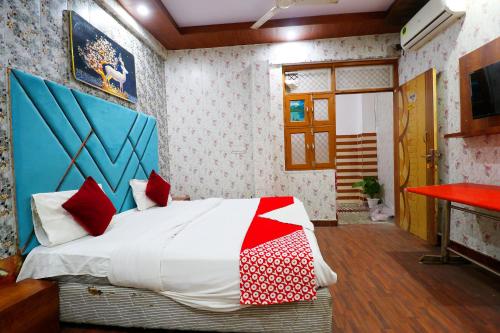 a bedroom with a bed with red and white pillows at Hotel Hindon Residency "Couple Friendly" in Ghaziabad