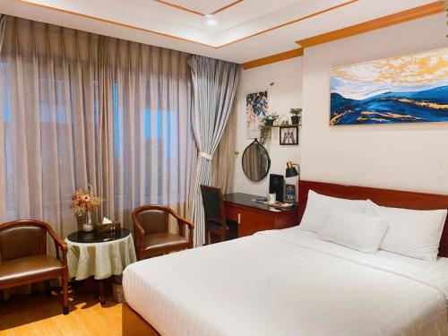 a hotel room with a bed and a desk and a window at THE STAR HOTEL - PHU MY HUNG, HO CHI MINH - Korean Buffet Breakfast in Ho Chi Minh City