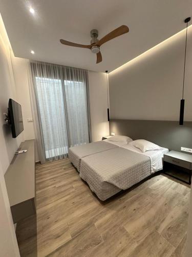 ein Schlafzimmer mit Bett und Deckenventilator in der Unterkunft Aspa Holidays in Kos-Stadt