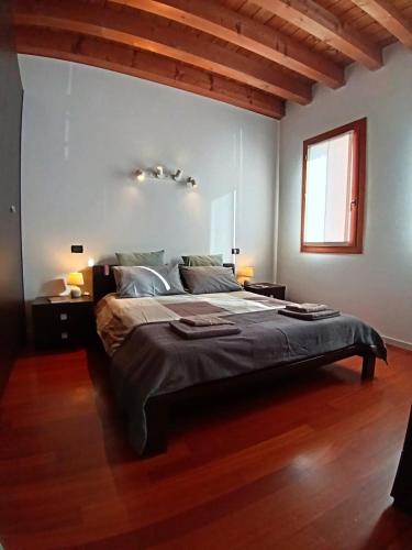 a bedroom with a large bed and a wooden floor at Dietro la piazza in Marostica