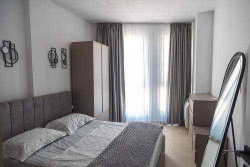 a bedroom with a bed and a large window at Salt & Serenity Apartment in Orikum
