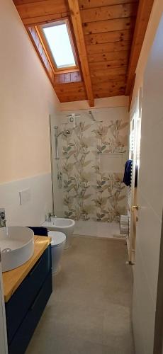 a bathroom with two sinks and a toilet and a window at Casa del Moro al Sacro Monte app1 in Varese