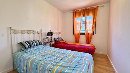 a bedroom with two beds and a window at Esglesia 7 2-4 in L'Estartit