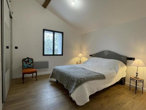 a bedroom with a bed and a window and a chair at Le gîte d'etxerria in Arhansus