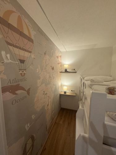 Ein kleines Zimmer mit einem Bett und einer Wand, an der ein Heißluftballon angebracht war. in der Unterkunft P-Hosting S3 in Schlier