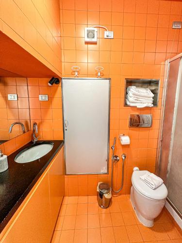a orange bathroom with a toilet and a sink at Vernazza Vacation in Vernazza