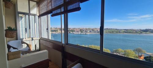 a room with windows with a view of the water at Apartamento vista Douro e Mar in Porto