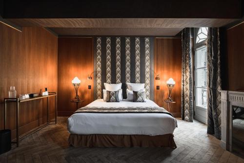 a bedroom with a large bed and two lamps at Maison Maubreuil in Nantes