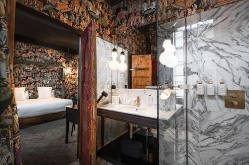 a bathroom with a shower and a sink and a bed at Maison Maubreuil in Nantes