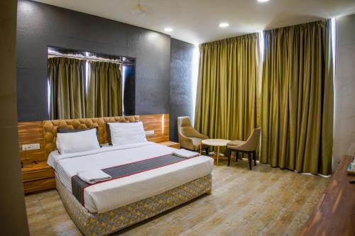 a bedroom with a bed and a table and chairs at Shubhham Regency in kolkata