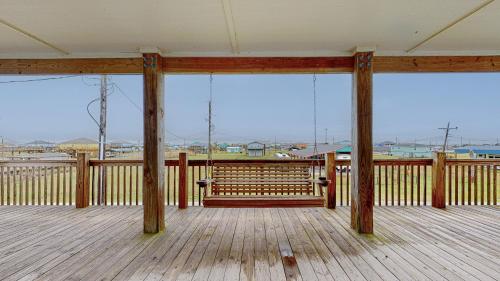 a wooden porch with a bench on a deck at Casa Siwichi home in Crystal Beach