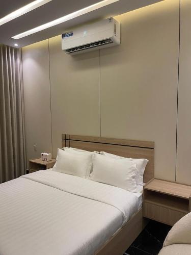 a bedroom with a bed with a air conditioner on the wall at فلل اسوار الوسام الفندقية in Taif