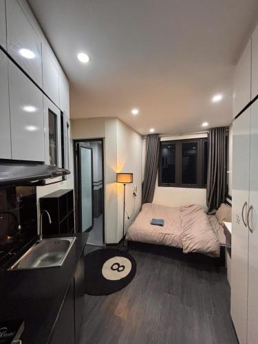 a small bedroom with a bed and a sink at Amoureux Cầu Diễn in Tây Tựu