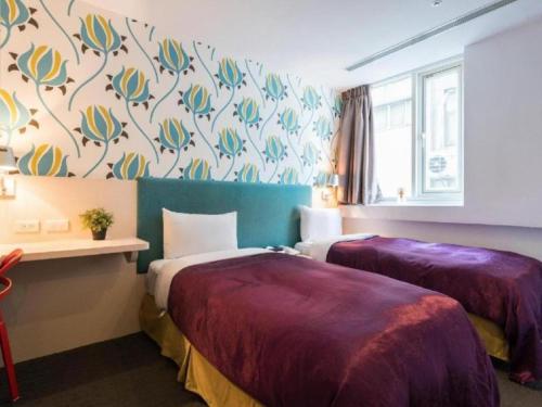 a hotel room with two beds with purple sheets at 西門大飯店 Ximen Hotel in Taipei