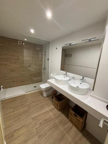 a bathroom with two sinks and a large mirror at Dúplex centro de Ribeira con WIFI by Cristian&Tamara"alquileres" in Ribeira