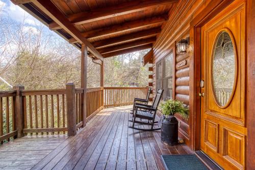a wooden porch with a rocking chair and a wooden door at Six-Bedroom House in Pigeon Forge