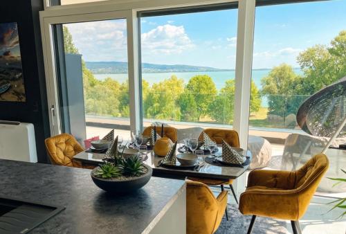 a dining room with a table and a large window at Premium Penthouse in Keszthely