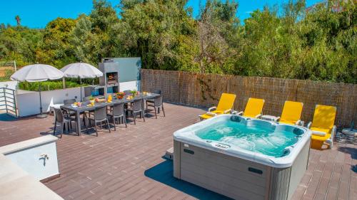 a hot tub on a patio with tables and chairs at Villa Bahamas - Jacuzzi e piscina aquecível em Armação de Pêra in Armação de Pêra
