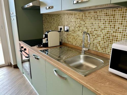 a kitchen with a sink and a microwave at Il Colle in Sanremo