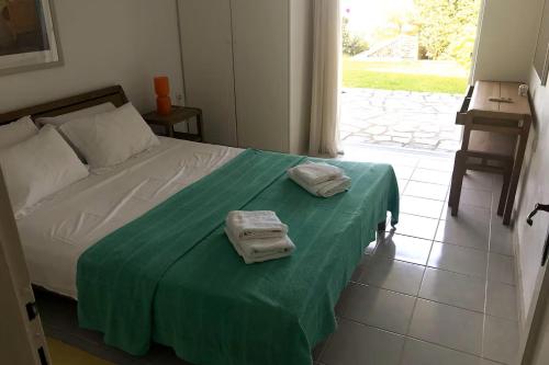 a bedroom with a bed with two towels on it at Villa Bienvenue Apartments in Kanapitsa