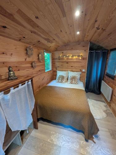 a bedroom in a log cabin with a bed in it at Roulotte enchantée in Cornillé-les-Caves