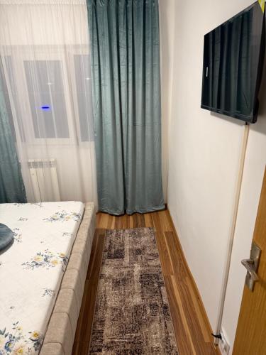 a room with a bed and a window with a television at Apart1 in Drobeta-Turnu Severin