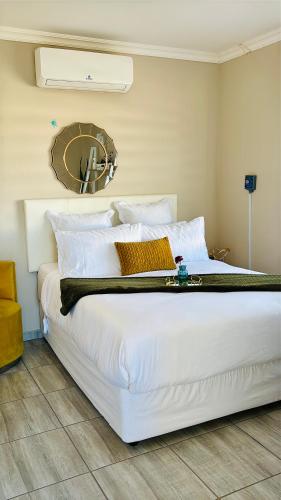 a large white bed in a bedroom with a mirror at Sunset Heaven in Newcastle