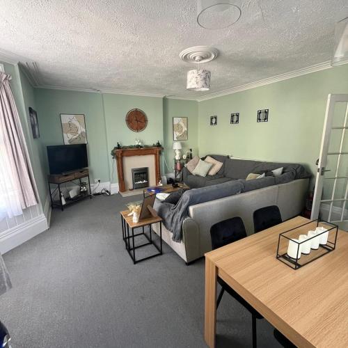 a living room with a couch and a table at The Pilgrims Cove in Burnham on Sea