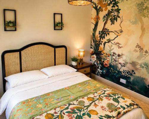 a bedroom with a large bed with a floral wallpaper at Greytree Cottage in Ross on Wye
