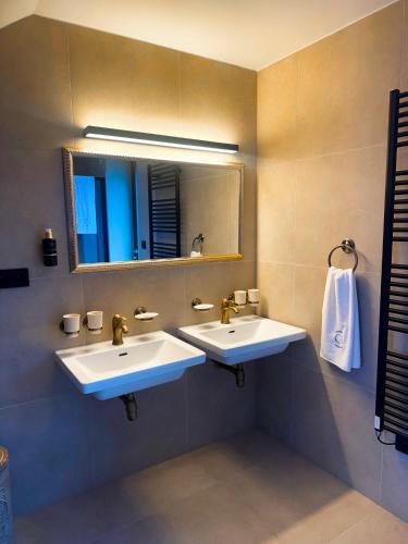 a bathroom with two sinks and a mirror at Vila CampoAmor Pasohlávky in Pasohlávky