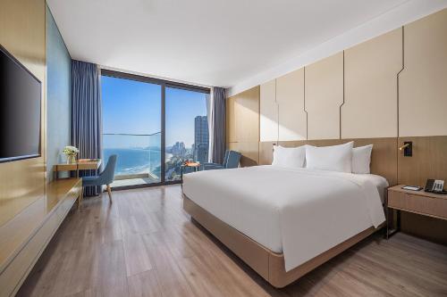 a hotel room with a large bed and a large window at Awaken Da Nang Hotel in Danang