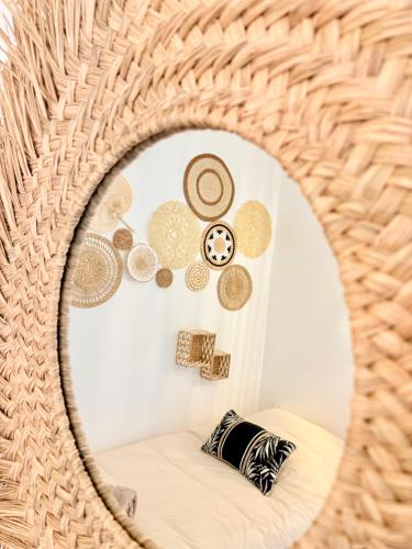 a wicker mirror in a room with a couch at Le Boudoir in Amboise