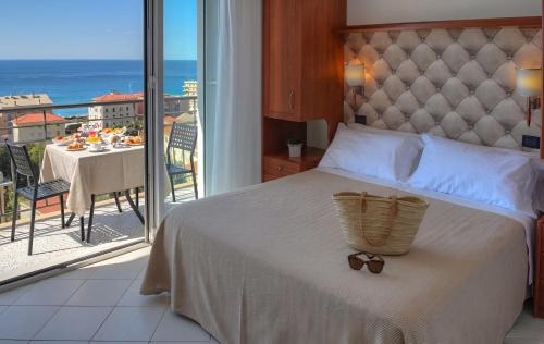 a bedroom with a bed and a view of the ocean at Hotel Noris in Finale Ligure